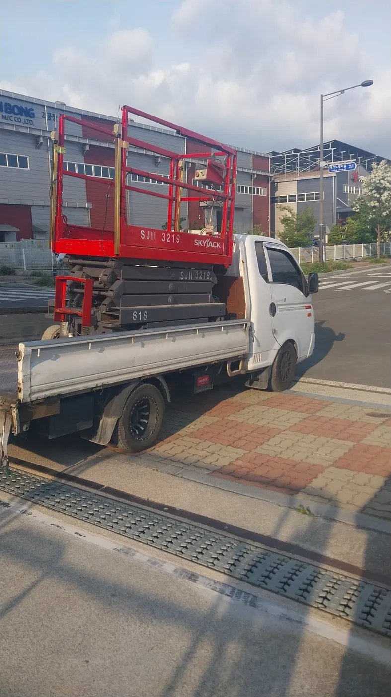 의령 고소작업대 상하차·운송 | 스마일테크 의령 현장 배차 중인 적색 고소작업대