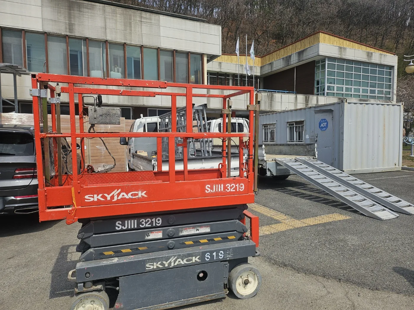 함안 고소작업대 현장 - 건물 외부에 배치된 적색 전동 고소작업대