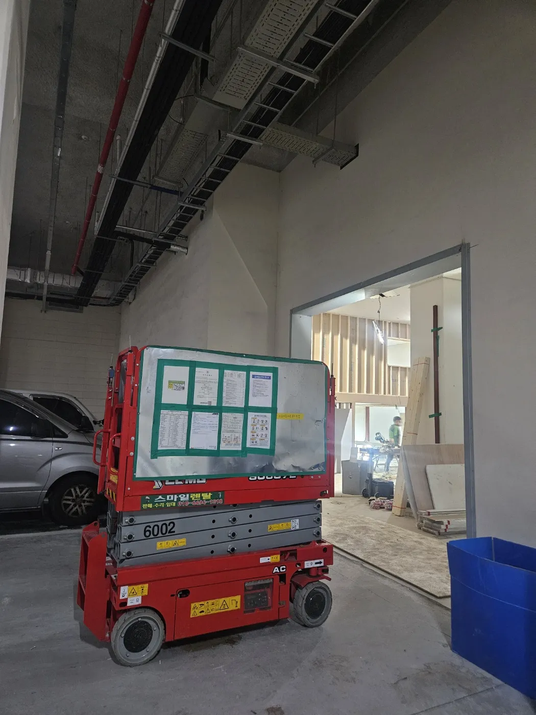 고성 실내 공사 공간에 배치된 적색 전동 고소작업대
